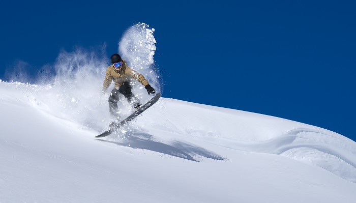 Esquiador probando el snowboard con nieve polvo 