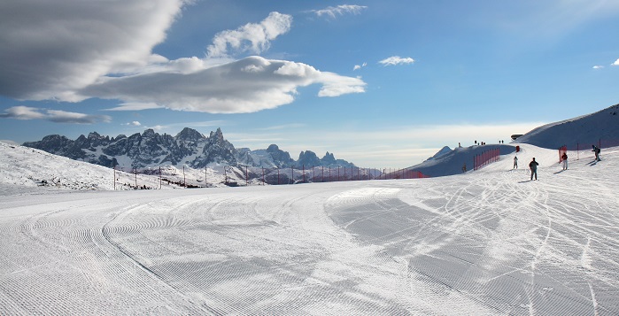 Pistas de esquí nevadas por completo con gente esquiando de fondo 
