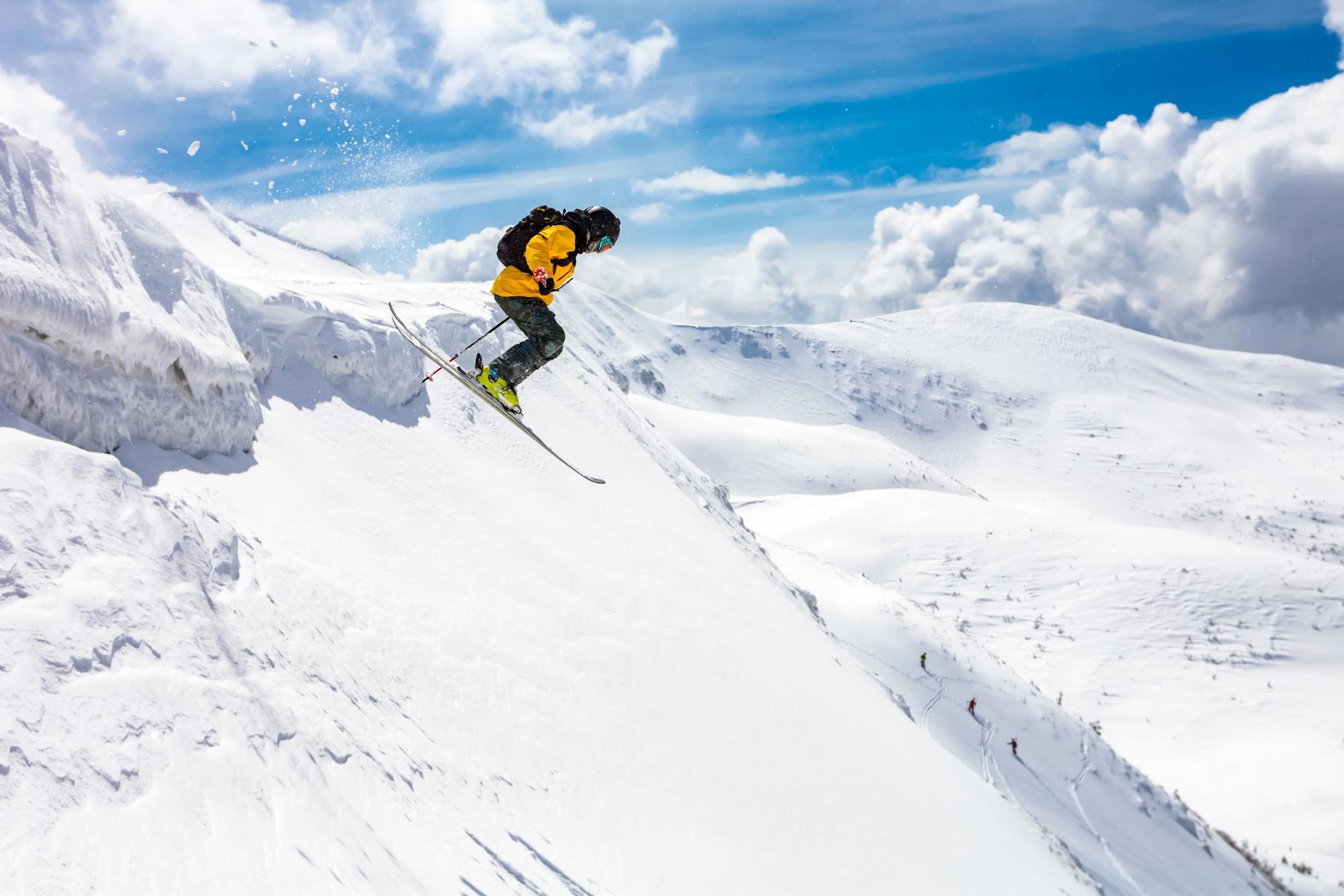 Esquiador vestido de amarillo haciendo freeride 