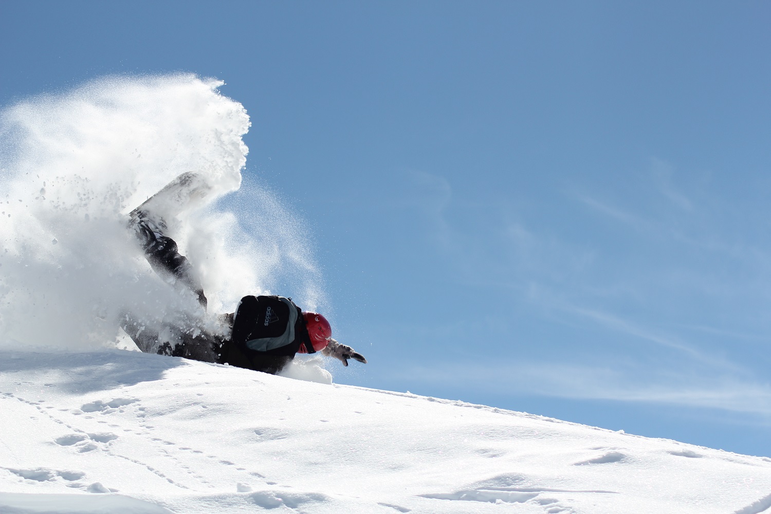 Esquiador haciendo snowboard mientras se cae en la nieve 