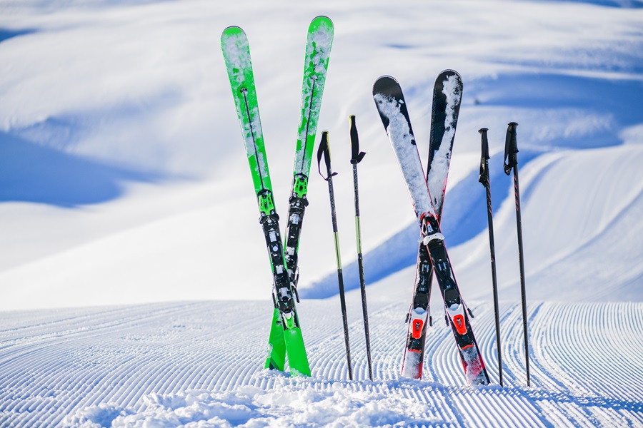 Dos pares de esquís clavados en la nieve con forma de x