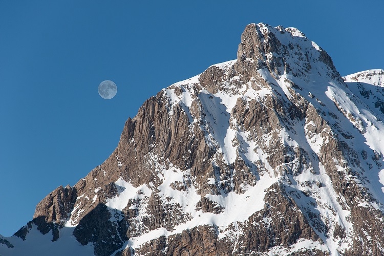 La luna llena detrás de una montaña en Candanchú
