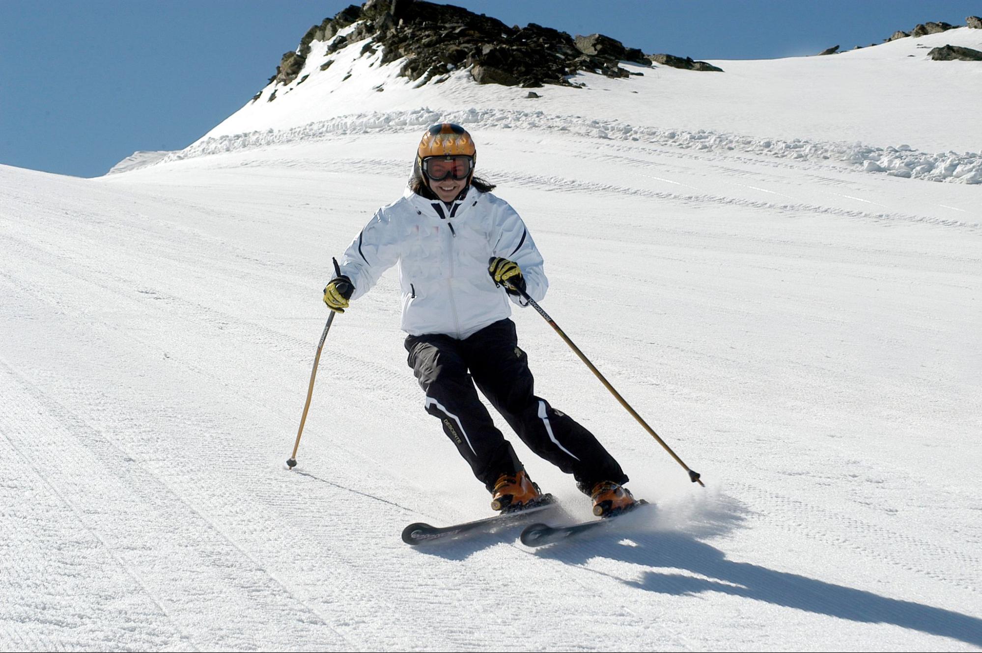 Mujer bajando una montaña esquiando a altas velocidades 